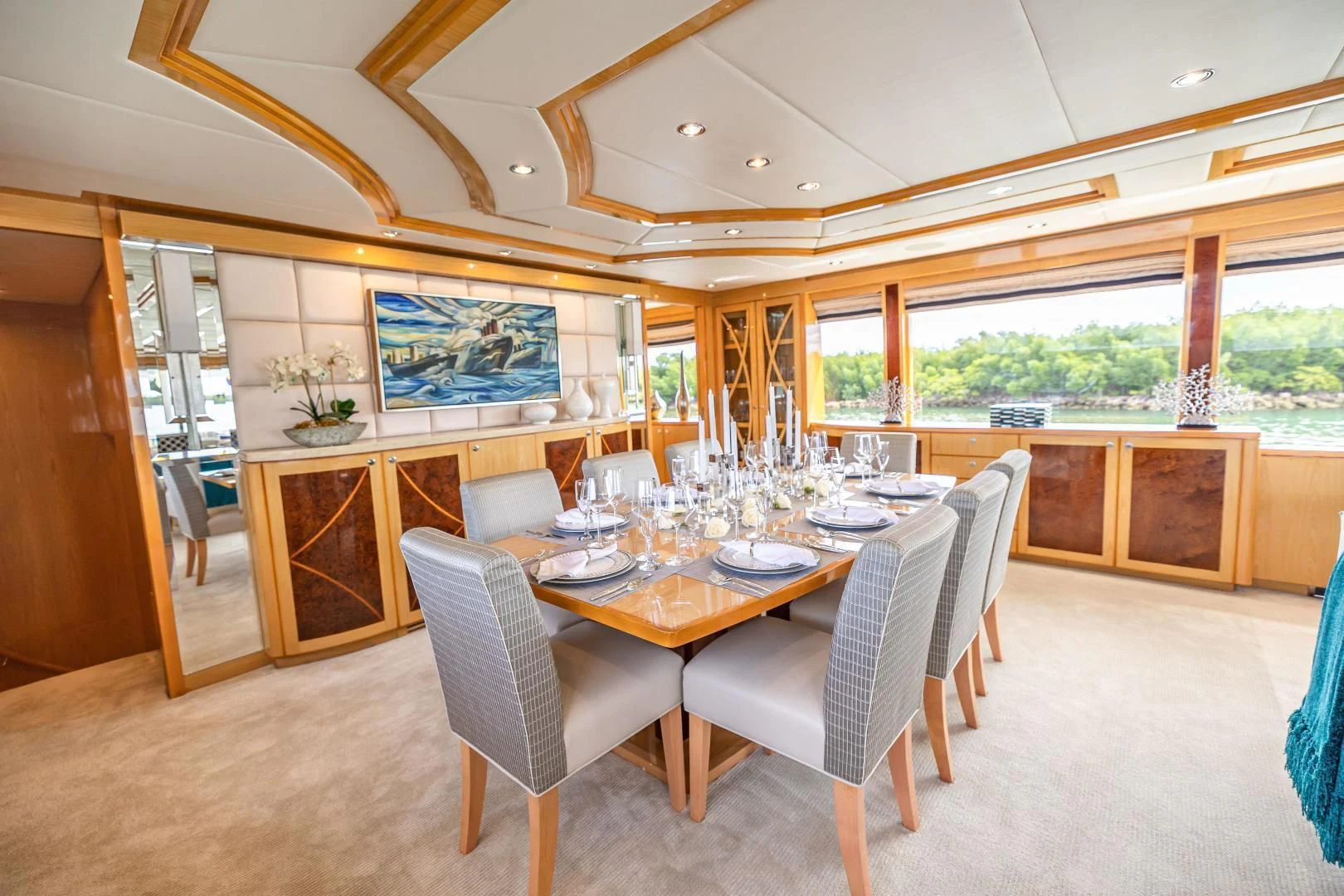 a dining table and chairs in a room with a large window aboard PINGUINITO Yacht for Sale