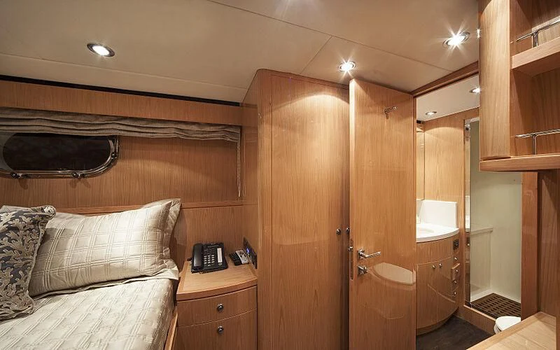 a bedroom with a bed and a phone aboard PINGUINITO Yacht for Sale