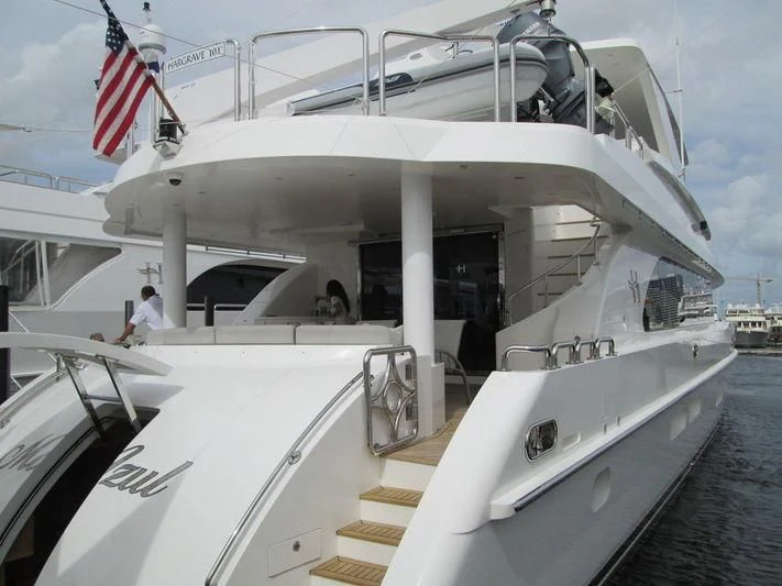 a large white boat with a flag on the front aboard PINGUINITO Yacht for Sale