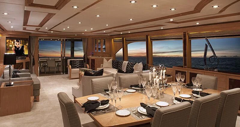 a room with a table chairs and a view of the ocean aboard PINGUINITO Yacht for Sale