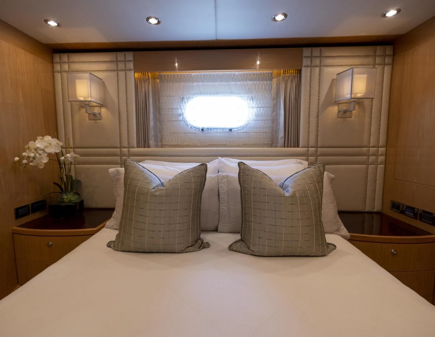 a bed with pillows and a window aboard PINGUINITO Yacht for Sale