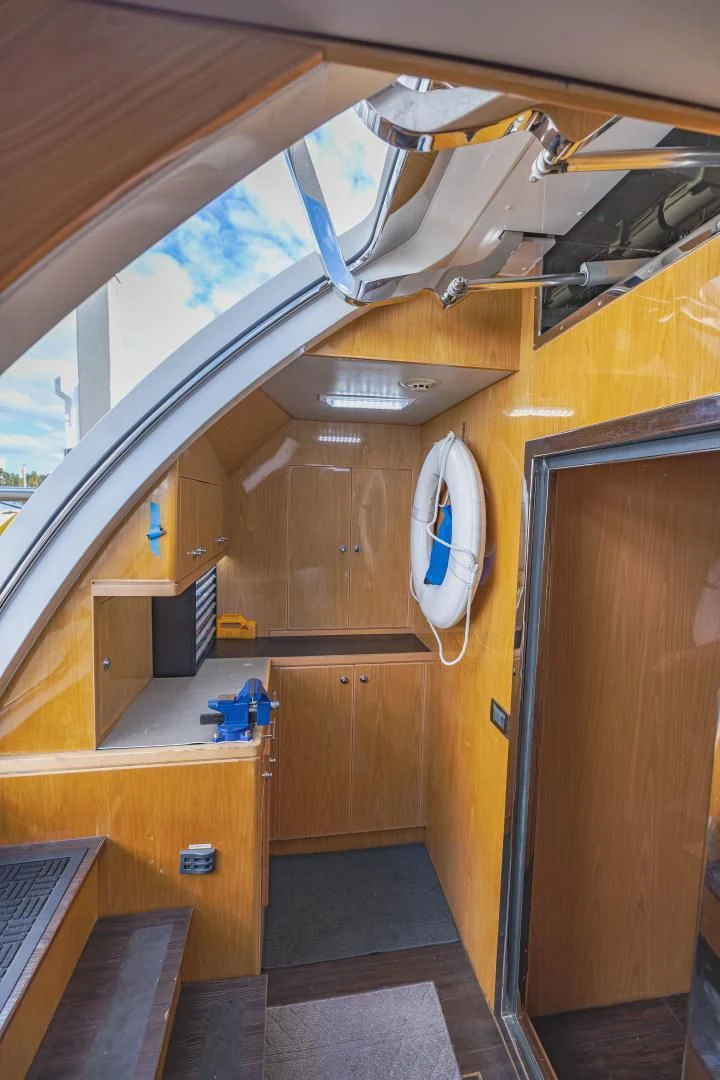 a wood room with a clock and a window aboard PINGUINITO Yacht for Sale