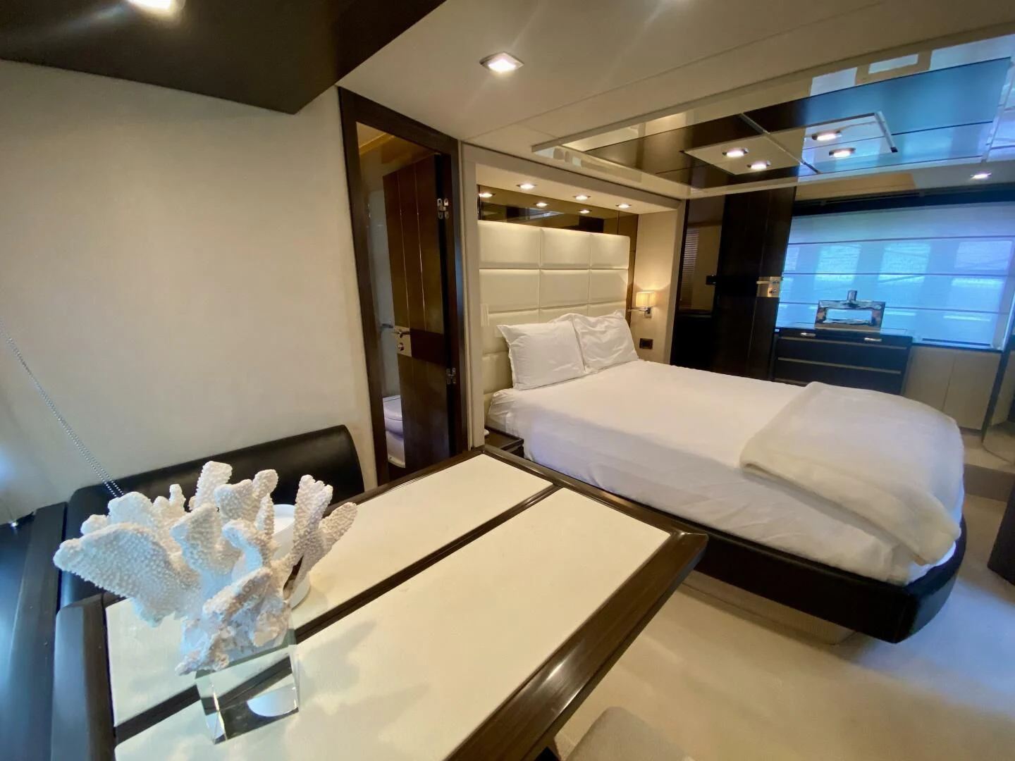a room with a bed and a table aboard SOMEWHERE I BELONG Yacht for Sale