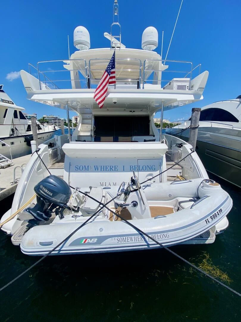 a boat with a flag on it aboard SOMEWHERE I BELONG Yacht for Sale