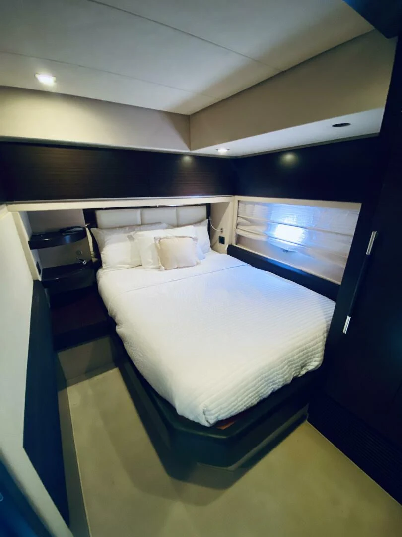 a room with a bed and a window aboard SOMEWHERE I BELONG Yacht for Sale