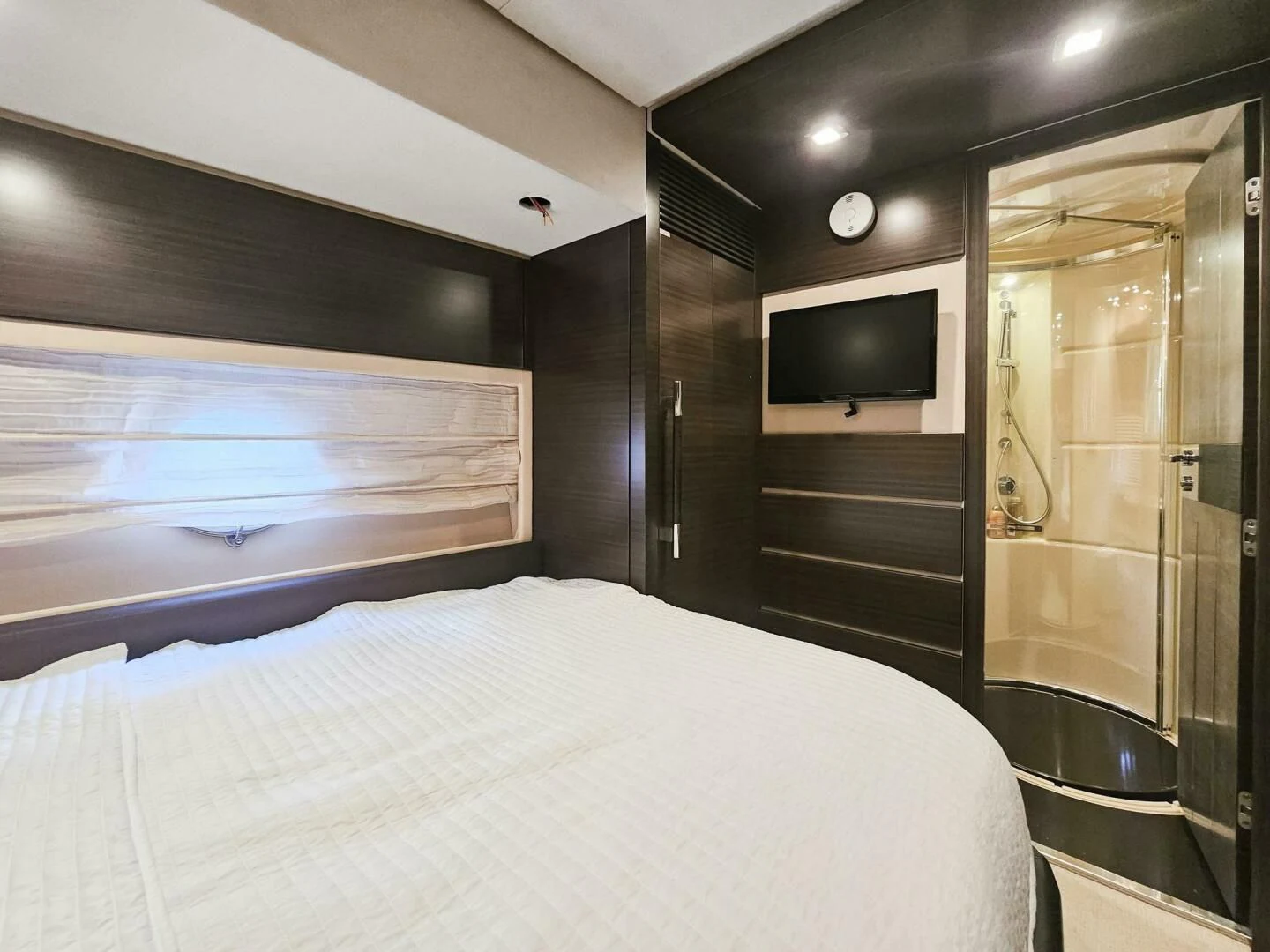 a bedroom with a bed and a television aboard SOMEWHERE I BELONG Yacht for Sale