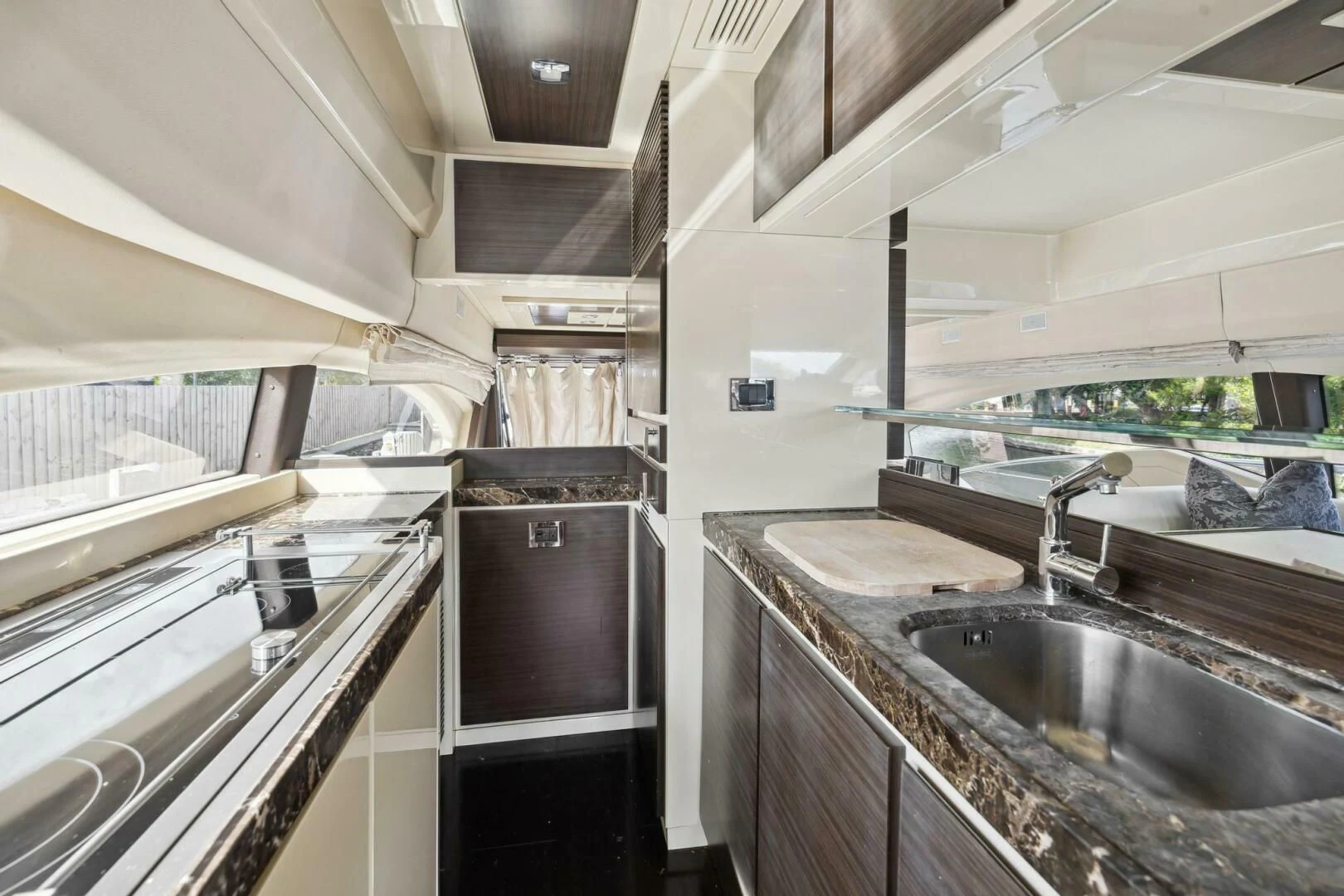 a kitchen with a sink and a large window aboard SOMEWHERE I BELONG Yacht for Sale