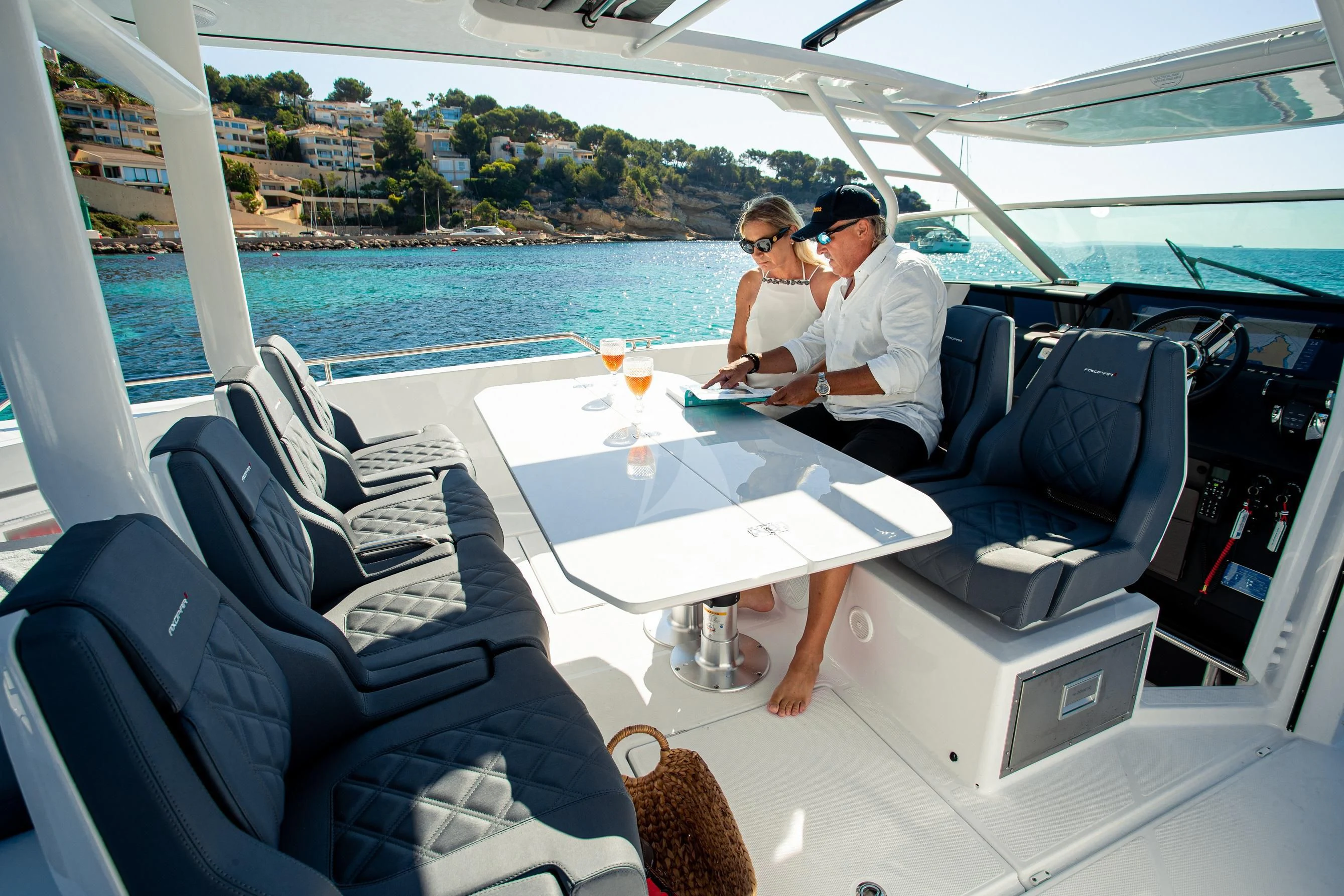 a couple sitting at a table on a boat aboard FIGURATI Yacht for Sale