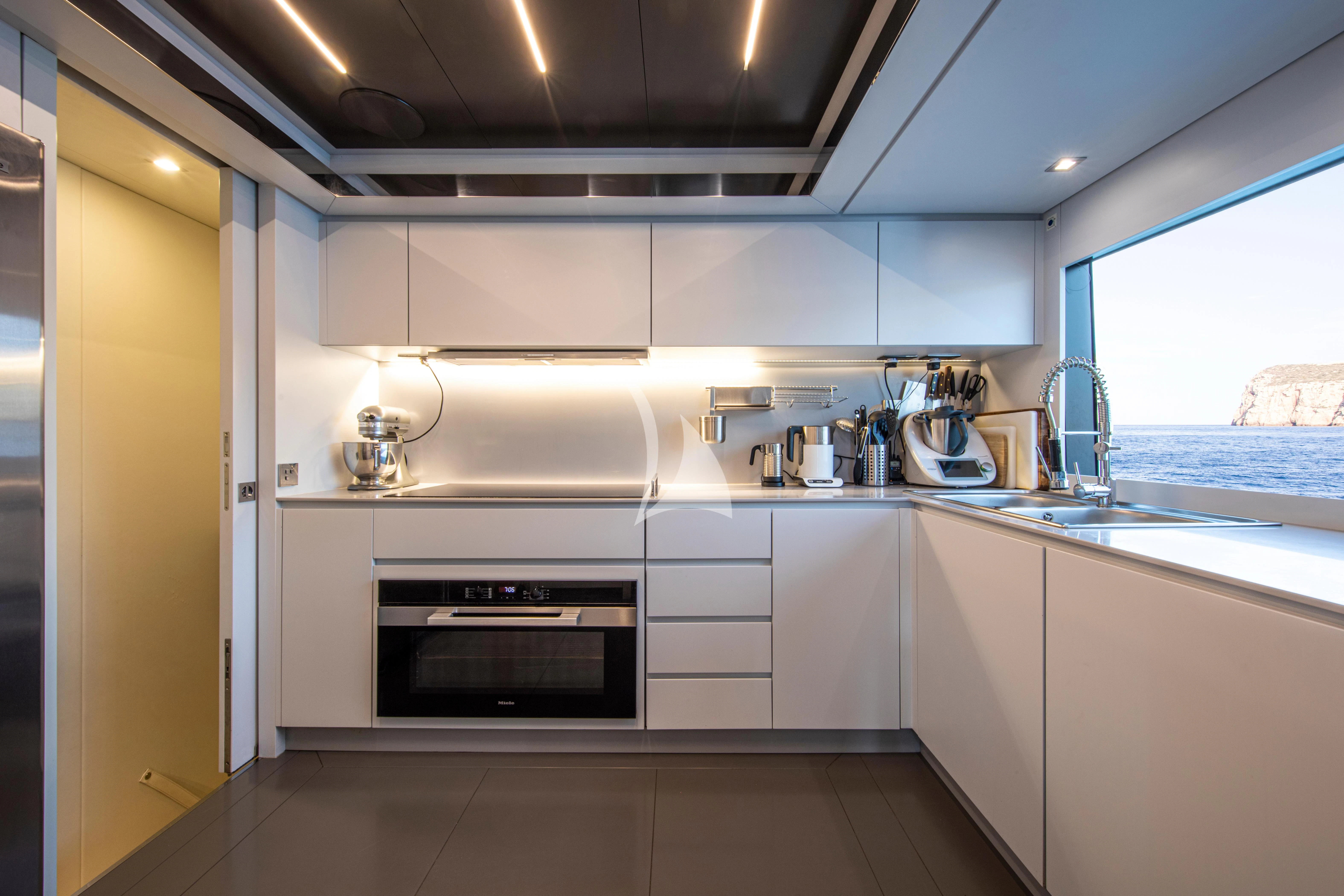 a kitchen with white cabinets aboard FIGURATI Yacht for Sale