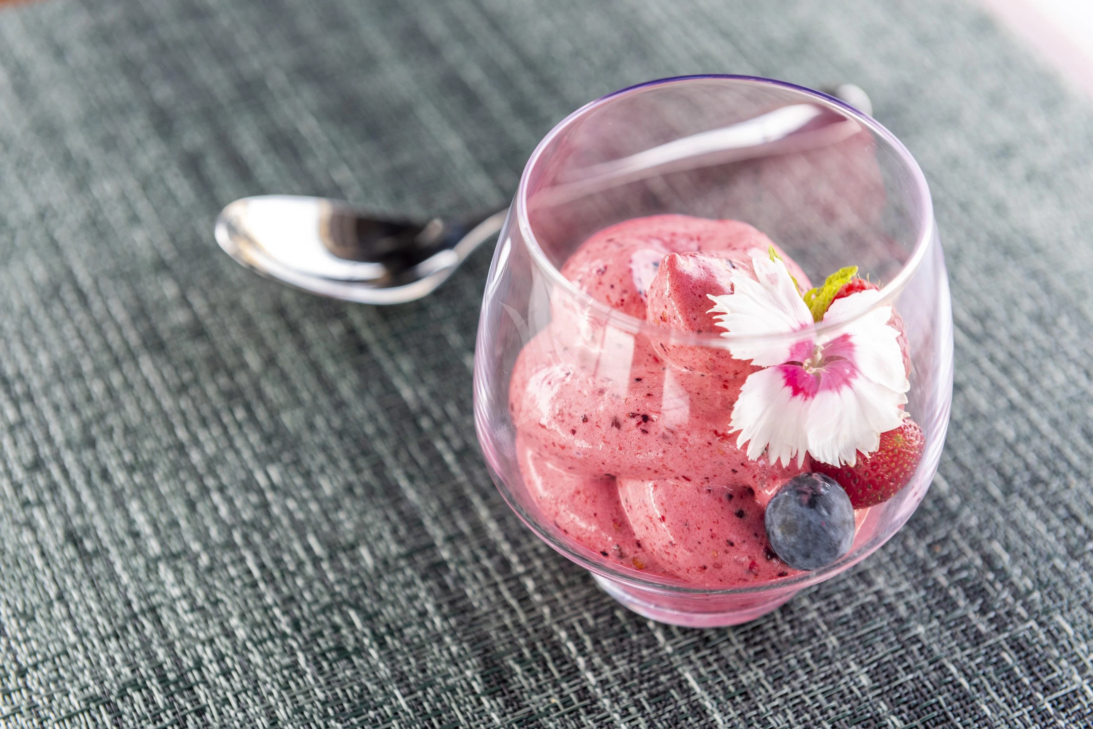 a glass of red liquid with a flower in it aboard FIGURATI Yacht for Sale
