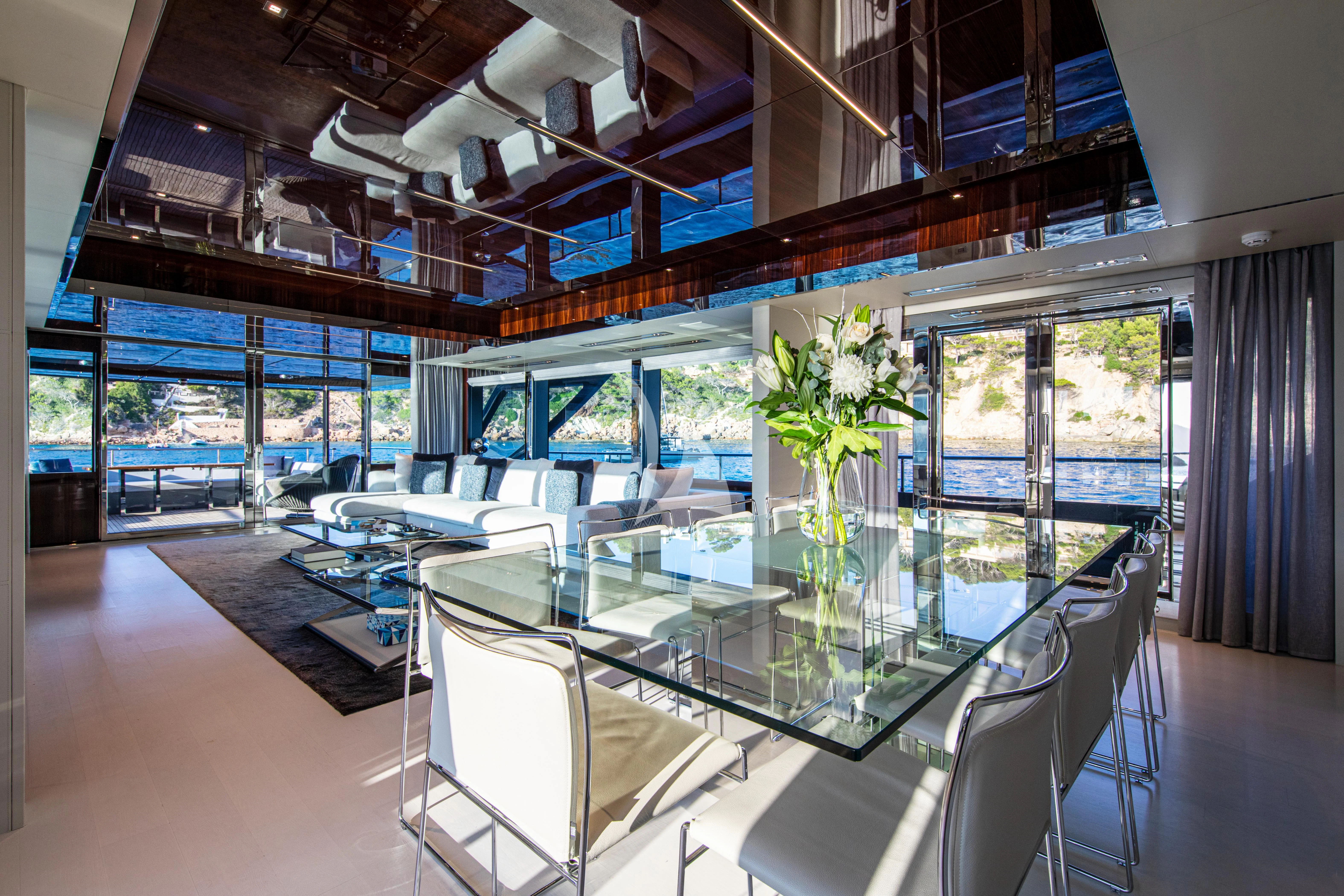 a room with a table chairs and flowers in it aboard FIGURATI Yacht for Sale