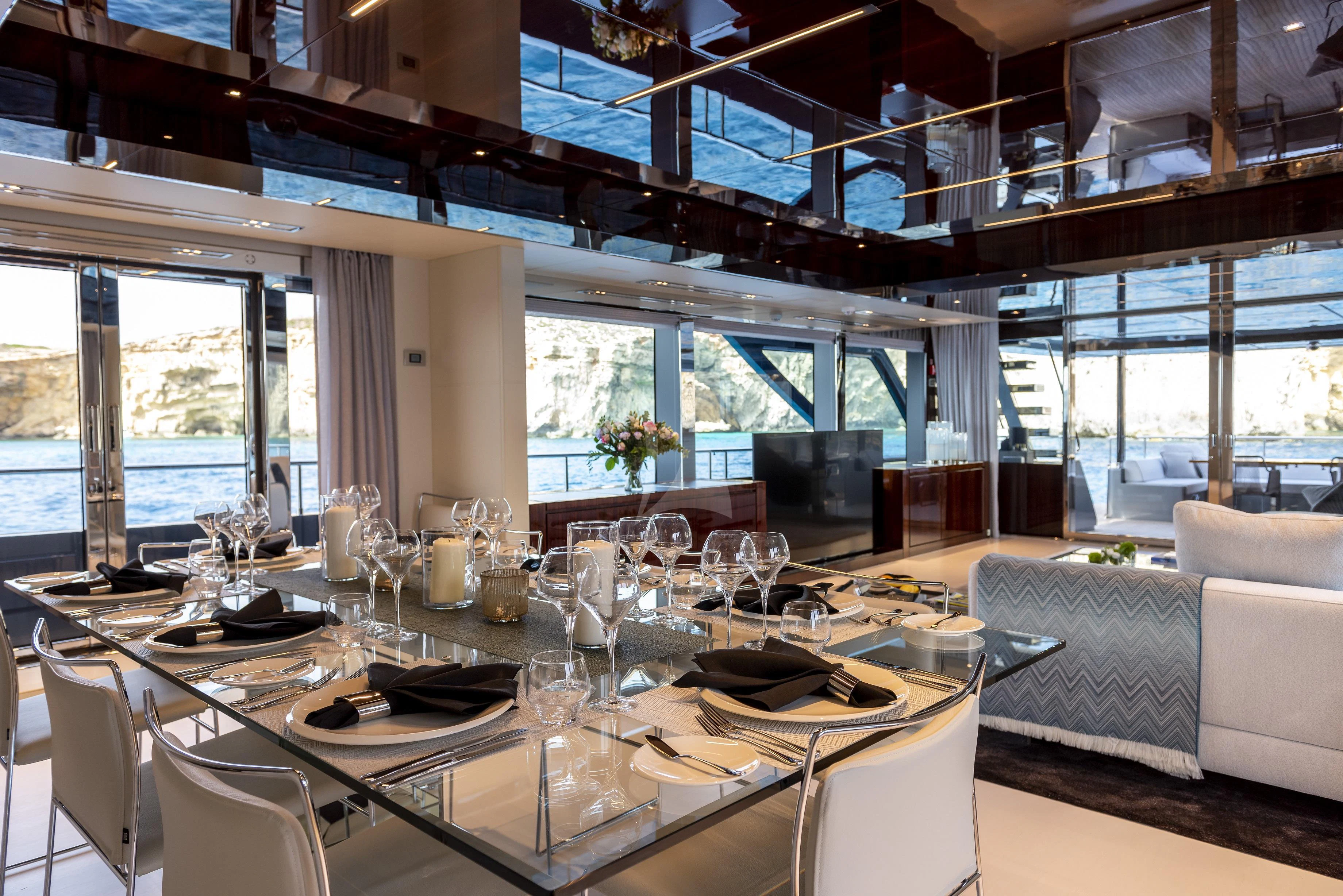a large dining table with white chairs aboard FIGURATI Yacht for Sale