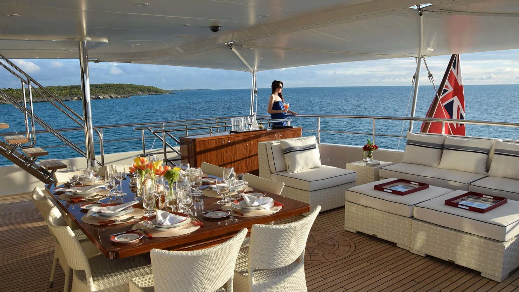 a person sitting on a table on a boat with a flag aboard BELLA Yacht for Sale