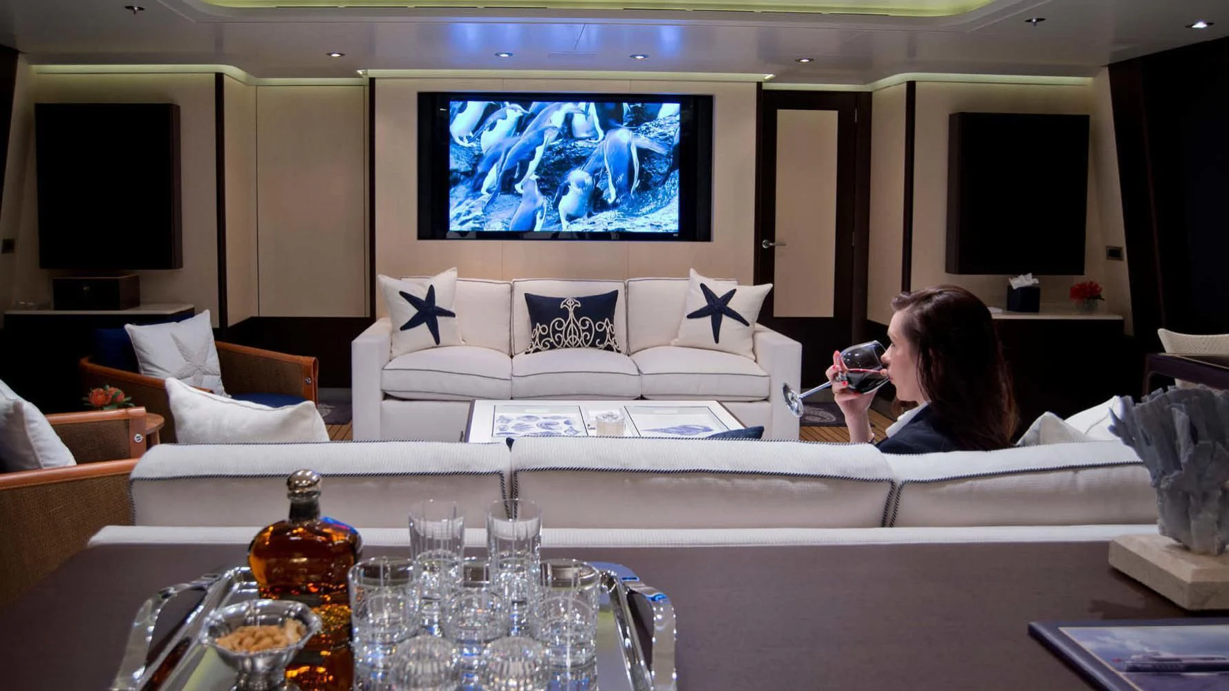 a person sitting on a couch watching tv aboard BELLA Yacht for Sale
