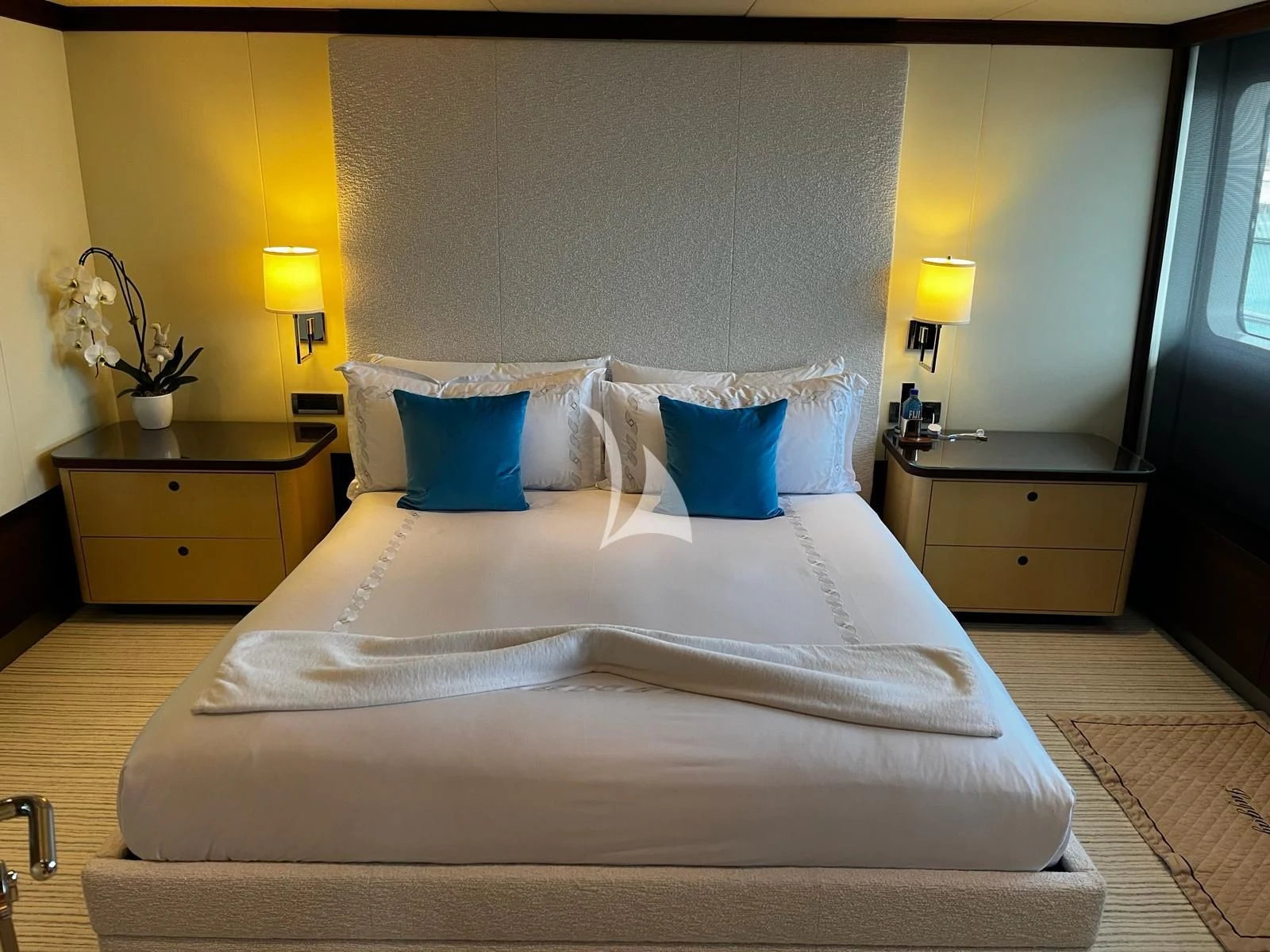 a bed with a white comforter and blue pillows aboard BELLA Yacht for Sale