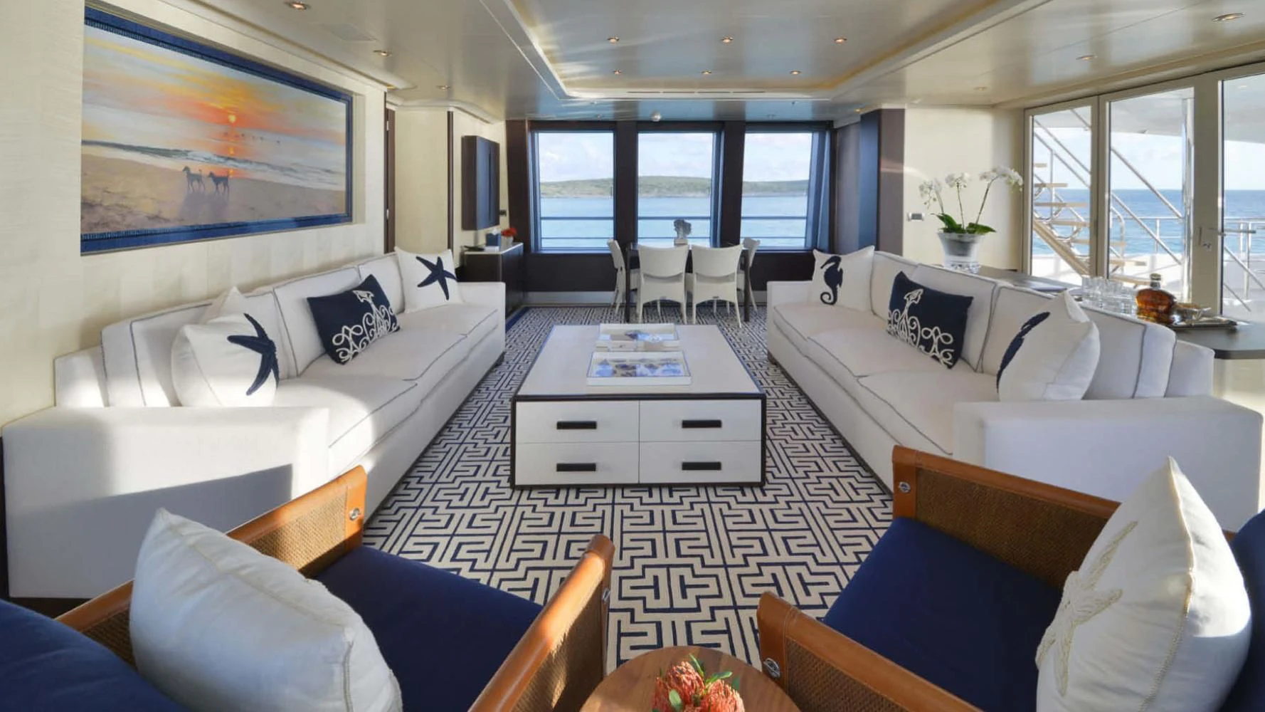 a room with white couches and a table with chairs aboard BELLA Yacht for Sale