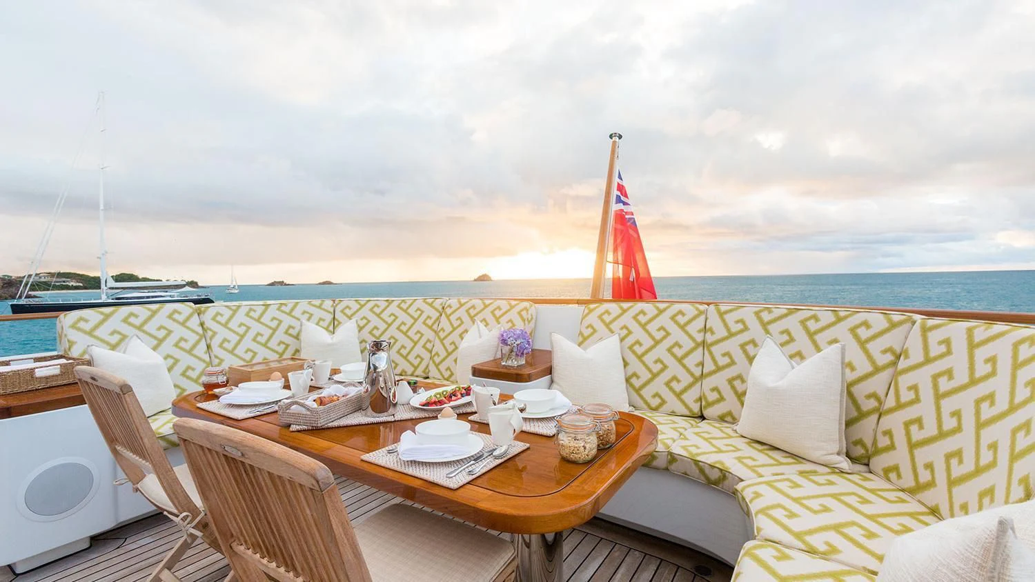 a table with chairs and a flag on it aboard MICHAELA ROSE Yacht for Sale