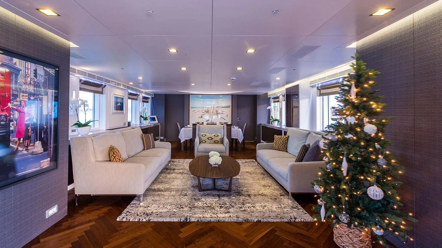 a living room with a christmas tree and a large screen aboard MICHAELA ROSE Yacht for Sale