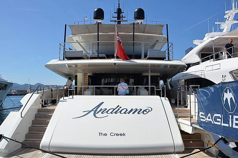 a boat with a flag on the deck aboard ANDIAMO Yacht for Sale
