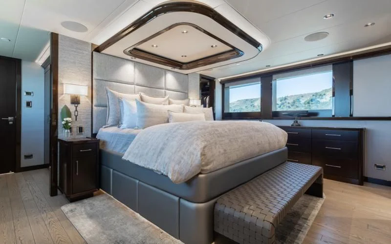 a bedroom with a bed and a large mirror aboard FIGARO Yacht for Sale