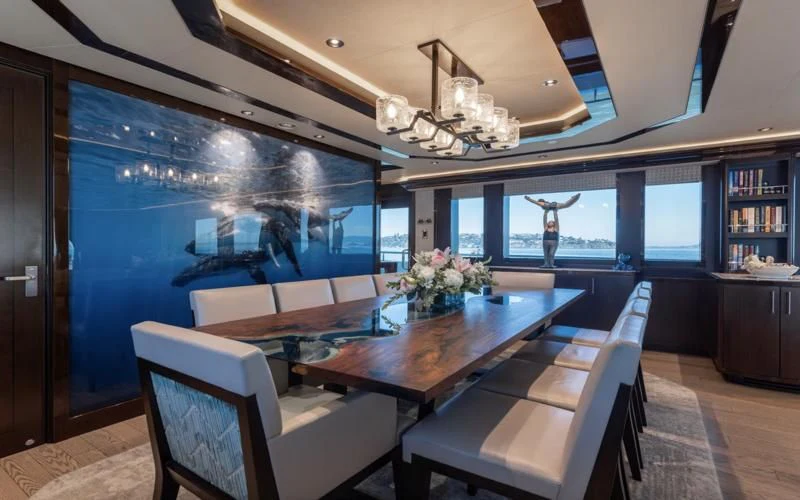 a room with a table chairs and a large window aboard FIGARO Yacht for Sale