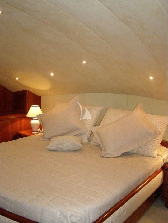 a bed with a white comforter and pillows aboard ABSOLUTE KING Yacht for Sale