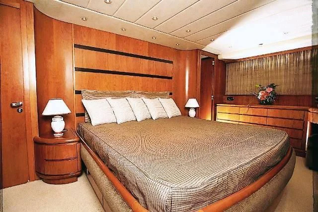 a bed with a wooden headboard aboard ABSOLUTE KING Yacht for Sale