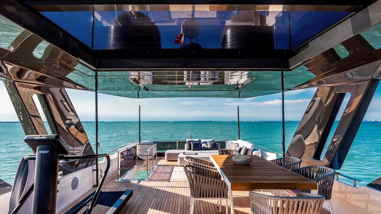 a deck with a table and chairs on it aboard TO INDIA Yacht for Sale