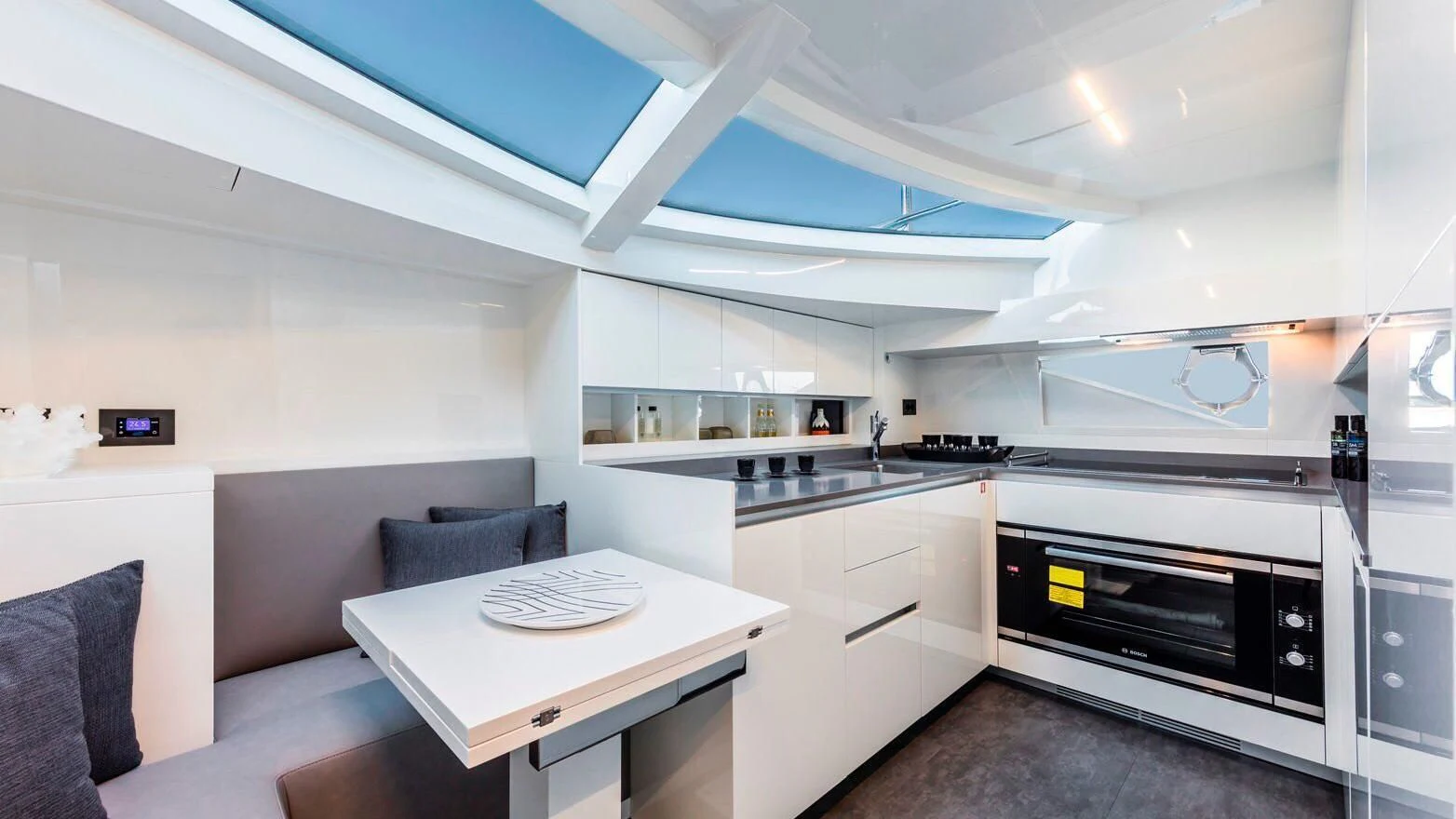 a kitchen with a table and couch aboard TO INDIA Yacht for Sale
