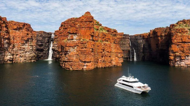 a boat in the water by a cliff aboard OCEAN DREAM Yacht for Sale