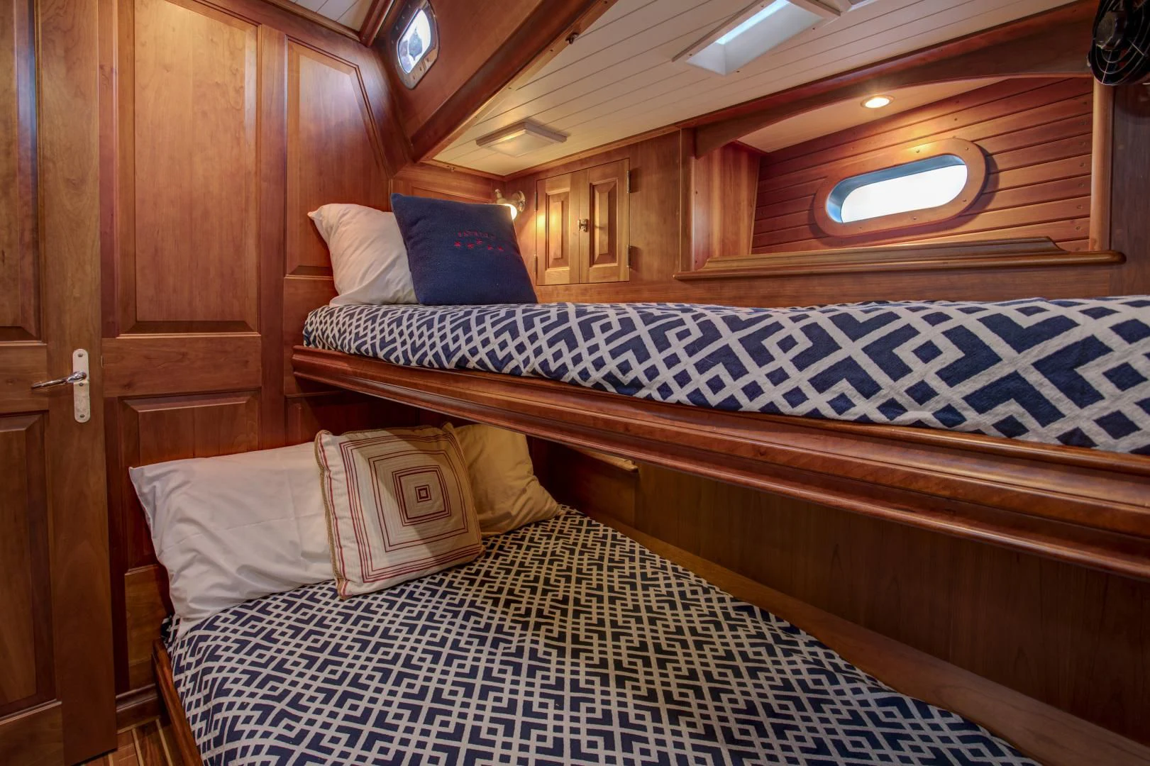 a bed with a blue and white checkered blanket aboard PATRIOT Yacht for Sale