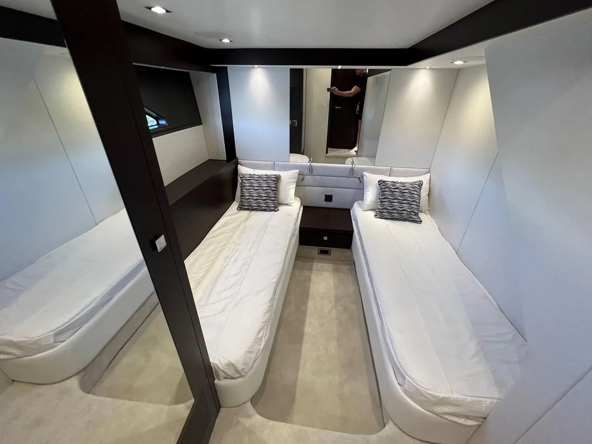 a room with a row of white beds aboard 66 MANHATTAN Yacht for Sale