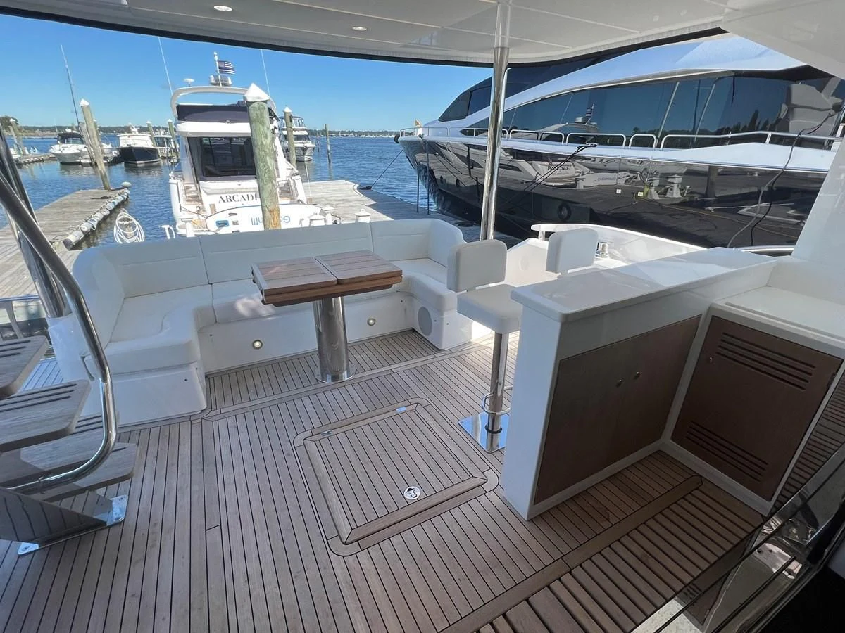a deck with a table and chairs on it aboard 66 MANHATTAN Yacht for Sale