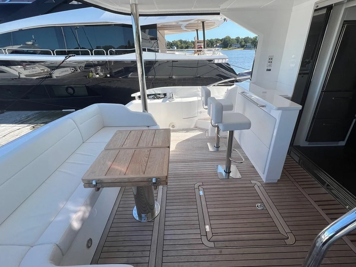 a deck with a table and chairs on it aboard 66 MANHATTAN Yacht for Sale