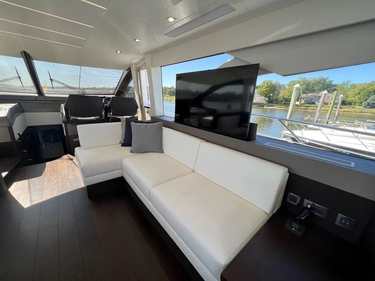 a room with a couch and a large window aboard 66 MANHATTAN Yacht for Sale