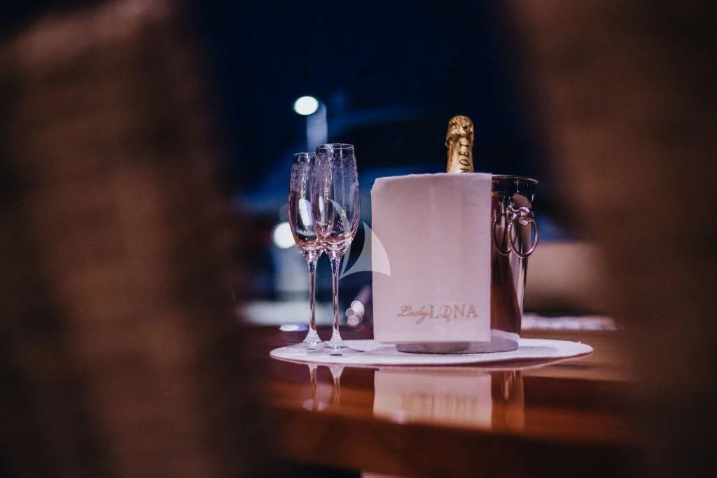 a glass of wine and a candle on a table aboard LADY LONA Yacht for Sale