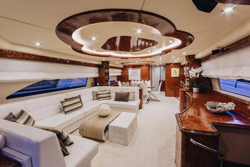 a room with a large white bed and a round table with chairs aboard LADY LONA Yacht for Sale