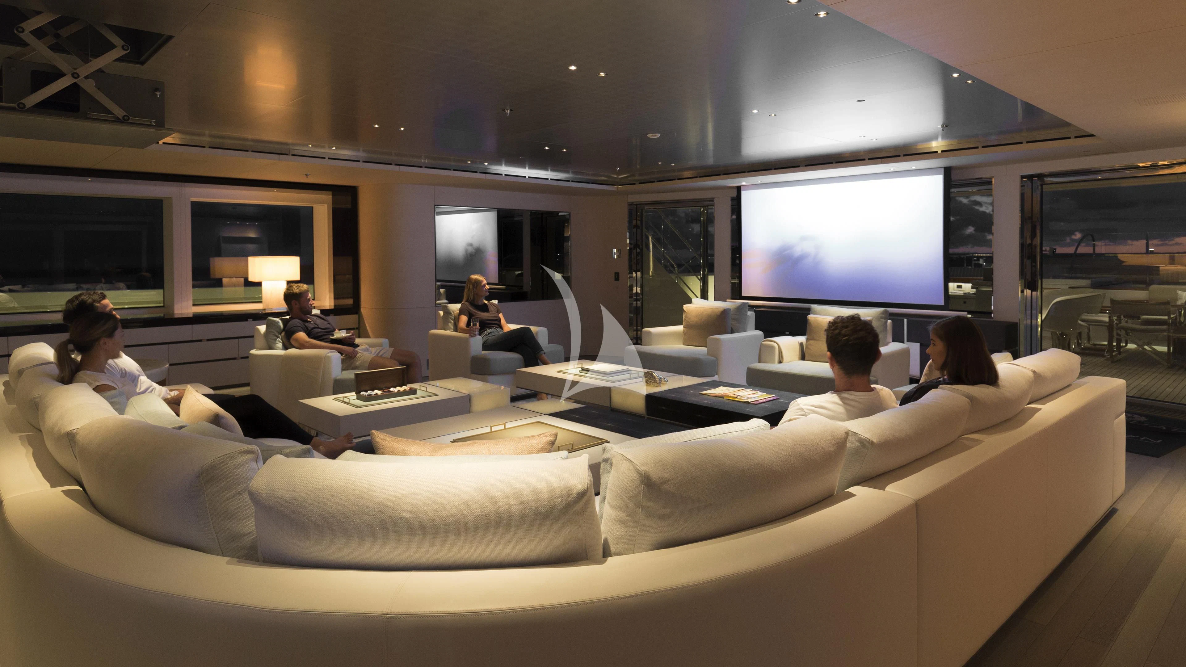 a group of people sitting on a couch in a room with a large screen aboard NAUTILUS Yacht for Sale