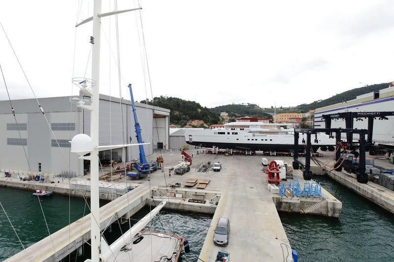 a boat dock with a walkway and a boat and a building in the background aboard NAUTILUS Yacht for Sale