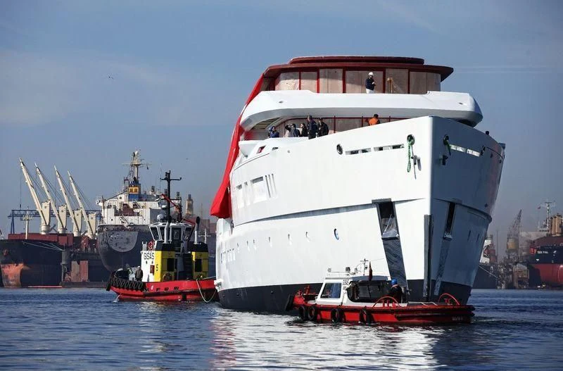 a large white ship with a red boat in the water aboard NAUTILUS Yacht for Sale