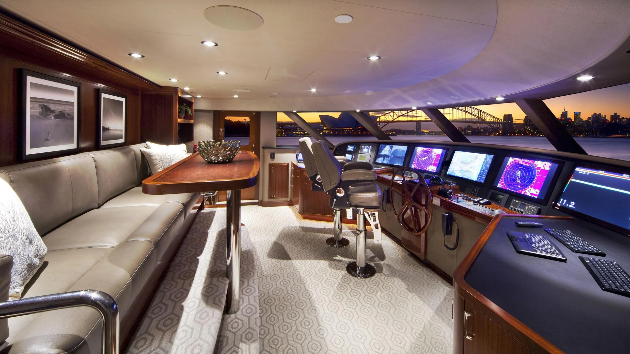 a room with a couch and a table with a chair and a television aboard WESTPORT 130 #4016 Yacht for Sale