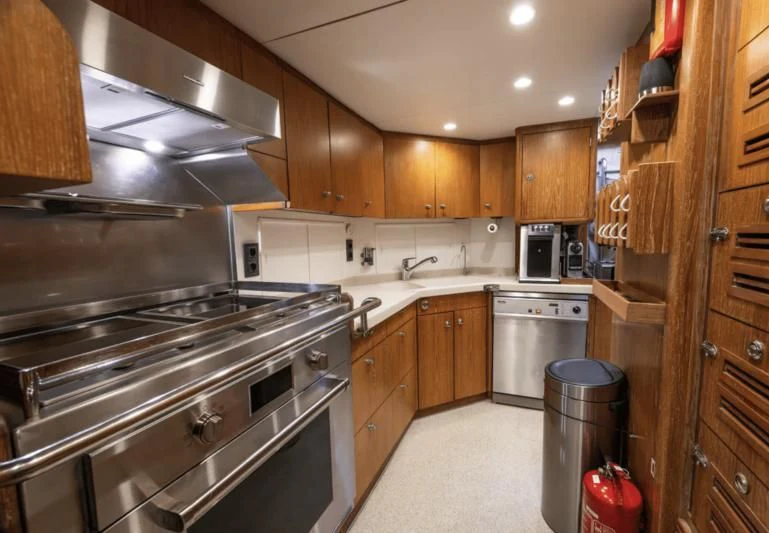 a kitchen with wooden cabinets aboard LA CATTIVA 1 Yacht for Sale