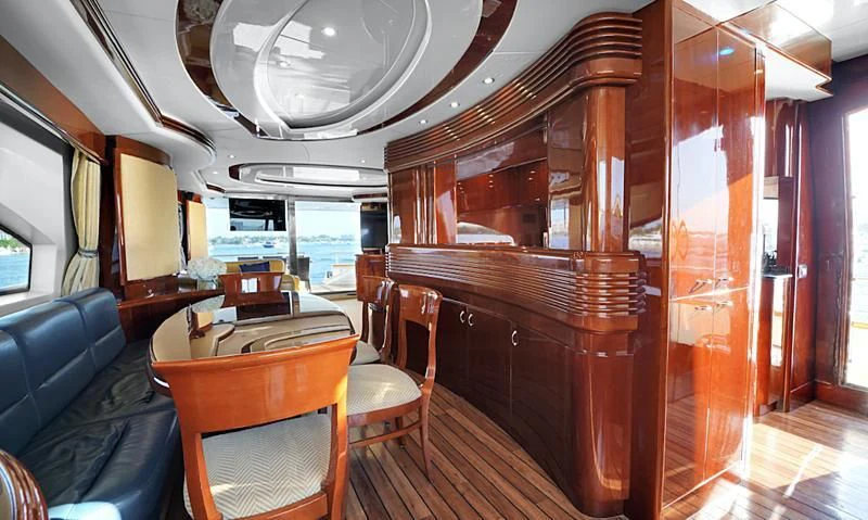 a room with a wood cabinet and chairs and a table with a couch aboard DELMAR Yacht for Sale