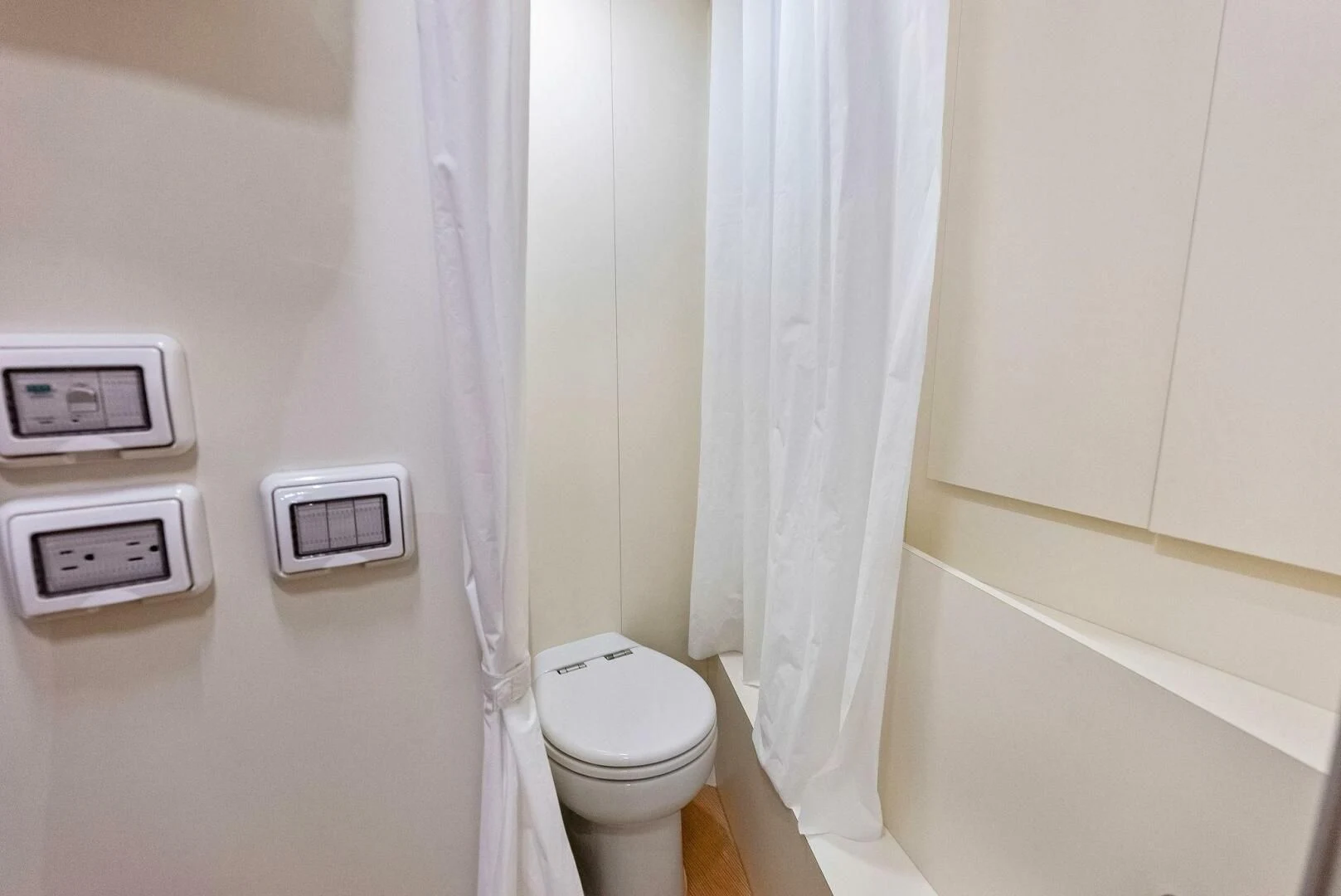 a toilet with a sink and a shower curtain aboard INEA Yacht for Sale