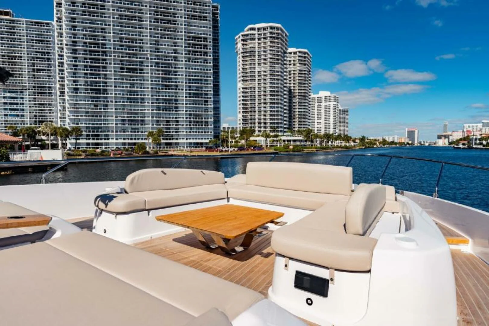 a room with a bed and a table and chairs on a deck with a city in the background aboard INEA Yacht for Sale