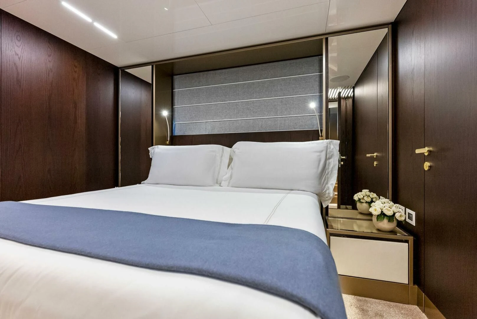 a bed with a blue comforter aboard INEA Yacht for Sale