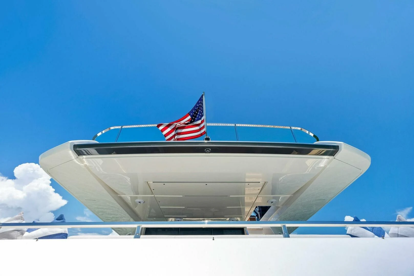 a white boat with a flag on the front aboard INEA Yacht for Sale