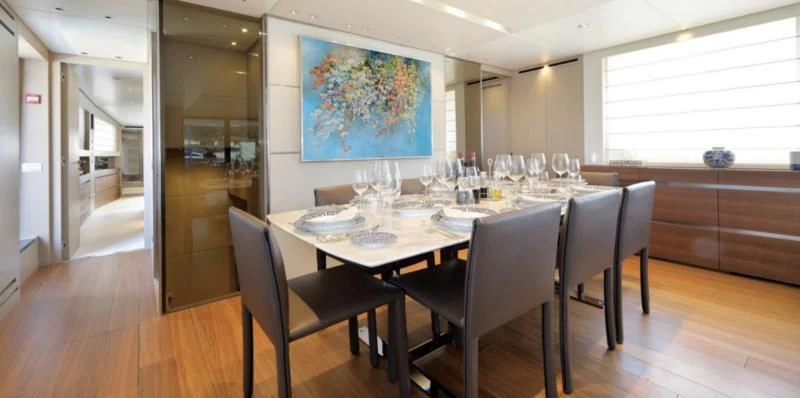 a dining room table with chairs aboard COBANA Yacht for Sale