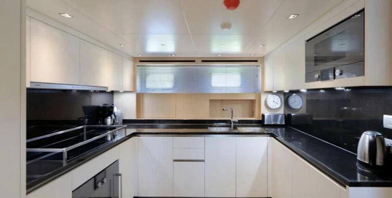 a kitchen with white cabinets aboard COBANA Yacht for Sale