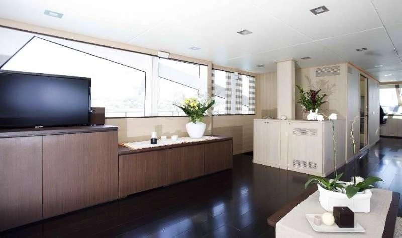 a room with a tv and a table aboard ARIA Yacht for Sale